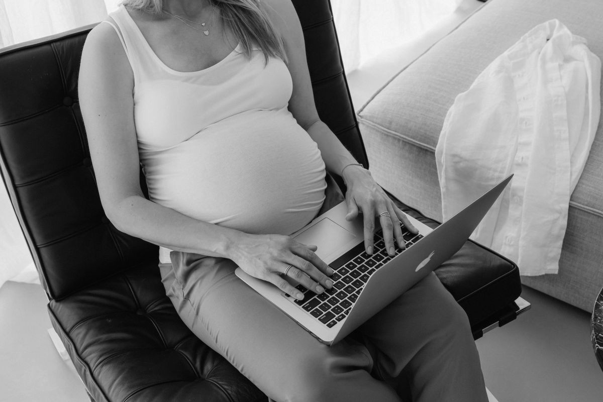 A pregnant woman researching labor and delivery tour questions on her laptop