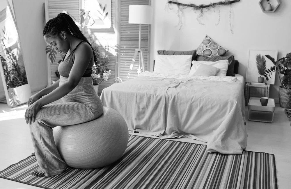 An expectant mother breathing through a contraction on a birth ball